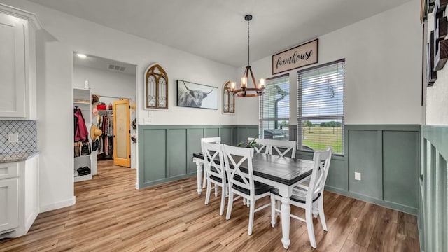 1401 County Road 1470, Chico, TX 76431 - dining area with a chandelier, light wood-style flooring, wainscoting, and a decorative wall