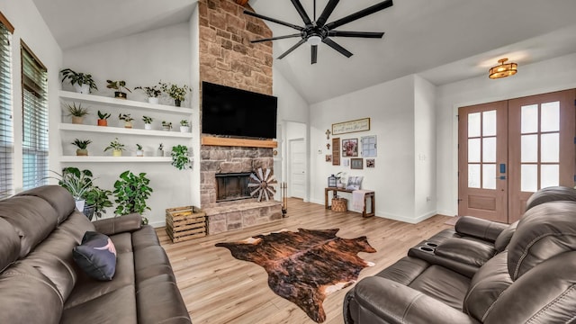 1401 County Road 1470, Chico, TX 76431 - living room featuring a ceiling fan, a fireplace, french doors, wood finished floors, and high vaulted ceiling
