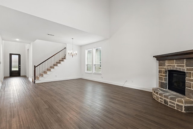 1519 Calcot Ln, Forney, TX 75126 - unfurnished living room with a chandelier, stairway, dark wood finished floors, and a stone fireplace