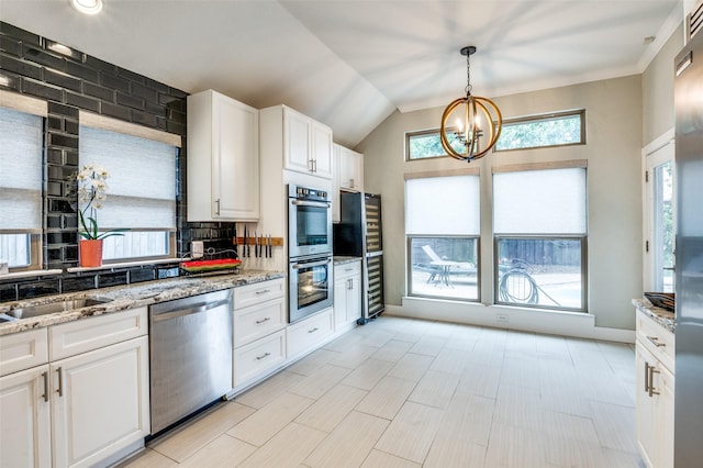 4320 Country Ln, Grapevine, TX 76051 - kitchen featuring stainless steel appliances, a chandelier, white cabinets, plenty of natural light, and lofted ceiling