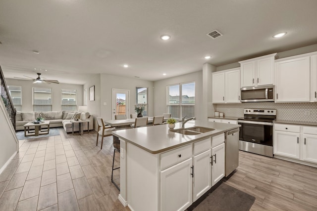 3018 Dakota Trl, Crandall, TX 75114 - kitchen with appliances with stainless steel finishes, tasteful backsplash, light wood-type flooring, white cabinets, and open floor plan