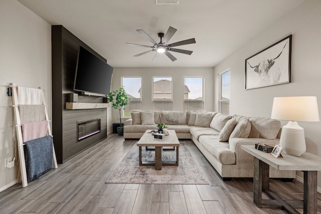 3018 Dakota Trl, Crandall, TX 75114 - living area with a large fireplace, ceiling fan, and wood finished floors