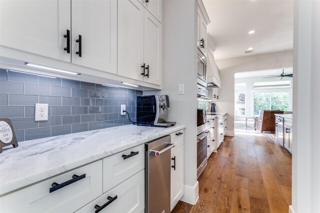 1757 Country Club Rd, Bowie, TX 76230 - kitchen featuring backsplash, wood finished floors, white cabinetry, light stone counters, and a ceiling fan