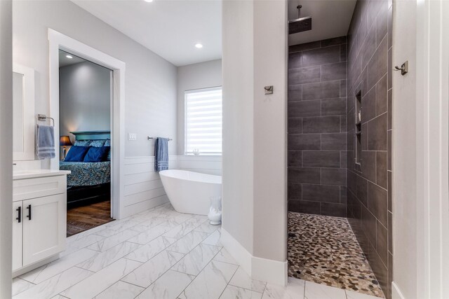 1757 Country Club Rd, Bowie, TX 76230 - ensuite bathroom with a soaking tub, a tile shower, marble look tiles, vanity, and a wainscoted wall