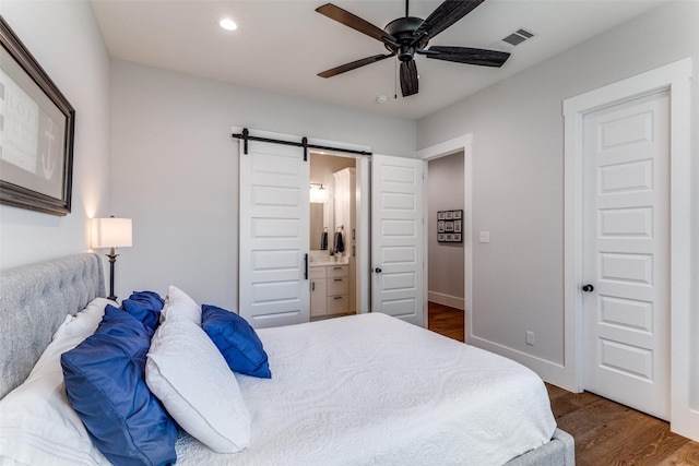 1757 Country Club Rd, Bowie, TX 76230 - bedroom featuring a barn door, dark wood-type flooring, recessed lighting, connected bathroom, and ceiling fan