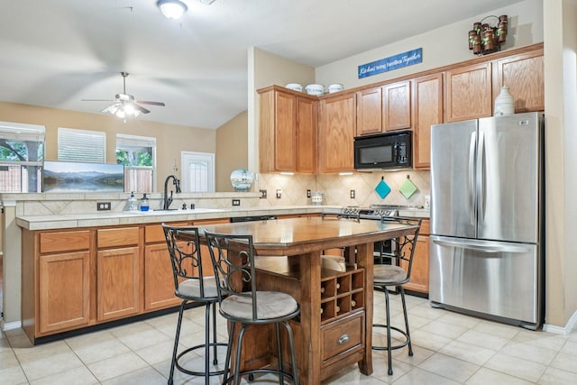 1323 Canyon Creek Rd, Wylie, TX 75098 - kitchen featuring freestanding refrigerator, black microwave, tasteful backsplash, a ceiling fan, and light tile patterned flooring