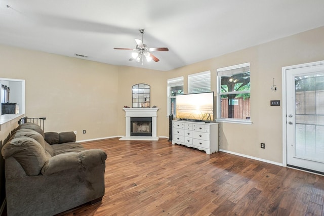 1323 Canyon Creek Rd, Wylie, TX 75098 - living area featuring a fireplace with raised hearth, a ceiling fan, and wood finished floors