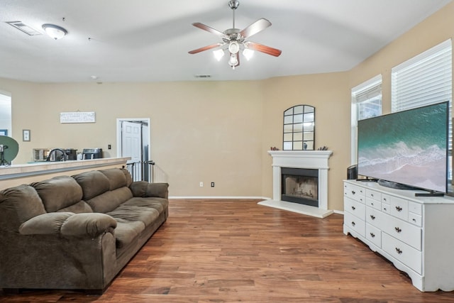 1323 Canyon Creek Rd, Wylie, TX 75098 - living room featuring a fireplace with raised hearth, wood finished floors, and a ceiling fan