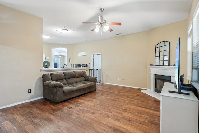 1323 Canyon Creek Rd, Wylie, TX 75098 - living room featuring ceiling fan, a fireplace with raised hearth, wood finished floors, and healthy amount of natural light