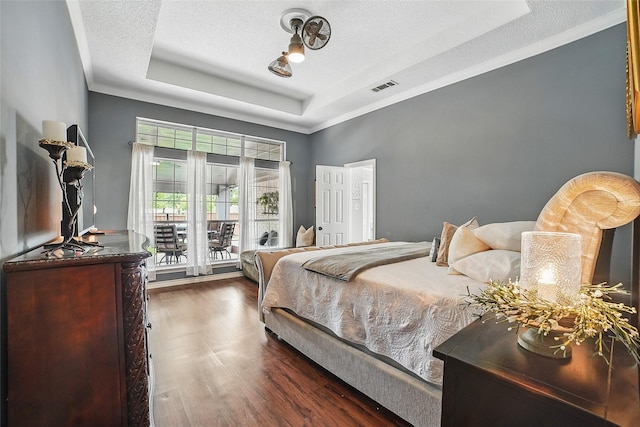 7104 Harlan Dr, Rockwall, TX 75087 - bedroom featuring a raised ceiling, wood finished floors, a textured ceiling, crown molding, and access to exterior