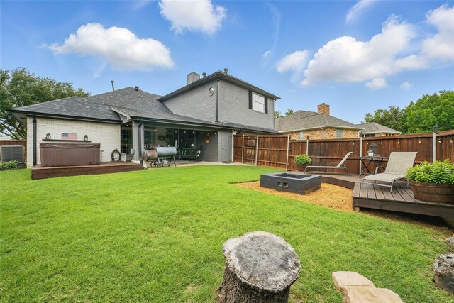 7104 Harlan Dr, Rockwall, TX 75087 - back of house with a hot tub, a fenced backyard, a deck, a chimney, and roof with shingles