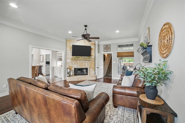 7104 Harlan Dr, Rockwall, TX 75087 - living area featuring ornamental molding, a fireplace, a ceiling fan, wood finished floors, and stairway