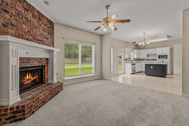 796 Oak Hollow Ln, Rockwall, TX 75087 - unfurnished living room with light carpet, a chandelier, a ceiling fan, a textured ceiling, and a fireplace