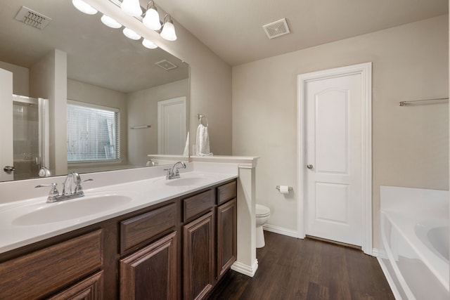 6524 Sheridan Cir, Arlington, TX 76017 - bathroom featuring wood finished floors, double vanity, a bath, and a shower with shower door