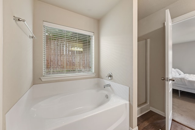 6524 Sheridan Cir, Arlington, TX 76017 - ensuite bathroom featuring a garden tub, wood finished floors, and an enclosed shower