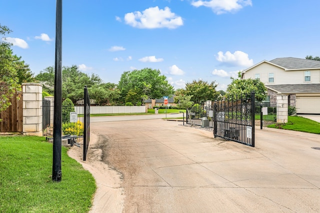 6524 Sheridan Cir, Arlington, TX 76017 - view of concrete street featuring a gate, a gated entry, and traffic signs