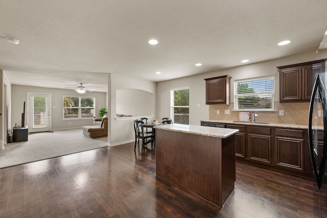 6524 Sheridan Cir, Arlington, TX 76017 - kitchen with a kitchen island, open floor plan, dark wood-style floors, dark brown cabinets, and a textured ceiling