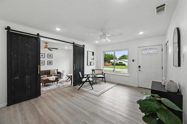 3105 Dupree St, Irving, TX 75062 - foyer featuring a barn door, ceiling fan, light wood-style floors, and recessed lighting