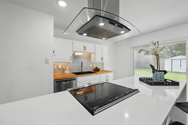 3105 Dupree St, Irving, TX 75062 - kitchen with island exhaust hood, stainless steel dishwasher, white cabinets, backsplash, and stovetop