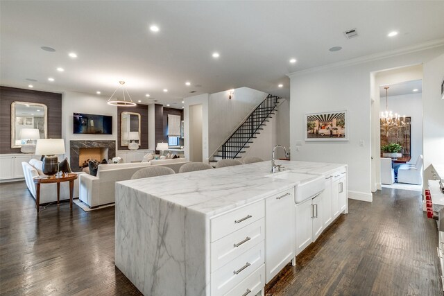 4635 W Amherst Ave, Dallas, TX 75209 - kitchen featuring light stone counters, white cabinetry, a kitchen island with sink, recessed lighting, and crown molding