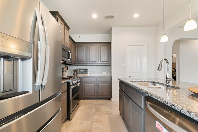 1112 Metaline Trl, Fort Worth, TX 76177 - kitchen with stainless steel appliances, arched walkways, light stone countertops, tasteful backsplash, and hanging light fixtures