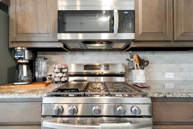 1112 Metaline Trl, Fort Worth, TX 76177 - kitchen with appliances with stainless steel finishes, decorative backsplash, and light stone countertops