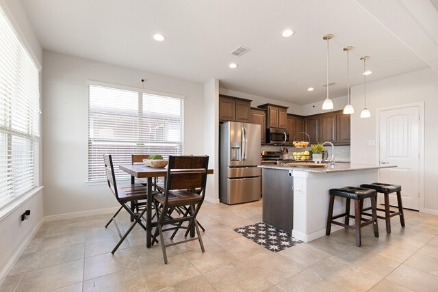 1112 Metaline Trl, Fort Worth, TX 76177 - kitchen featuring appliances with stainless steel finishes, a kitchen island with sink, a kitchen bar, recessed lighting, and pendant lighting