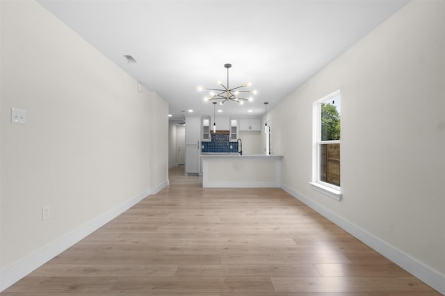 2117 Andrew Ave, Fort Worth, TX 76105 - unfurnished living room with a chandelier, light wood-style floors, and recessed lighting