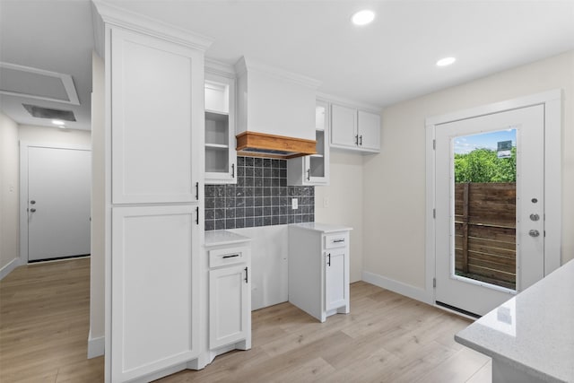 2117 Andrew Ave, Fort Worth, TX 76105 - kitchen with light wood-style floors, tasteful backsplash, white cabinetry, recessed lighting, and light stone counters