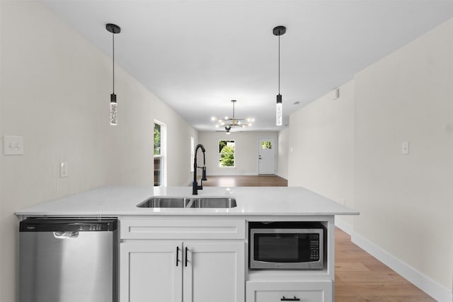 2117 Andrew Ave, Fort Worth, TX 76105 - kitchen featuring appliances with stainless steel finishes, a peninsula, white cabinets, light countertops, and pendant lighting