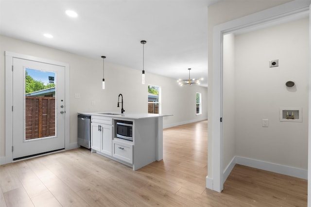 2117 Andrew Ave, Fort Worth, TX 76105 - kitchen featuring appliances with stainless steel finishes, light wood-style flooring, a peninsula, recessed lighting, and white cabinets