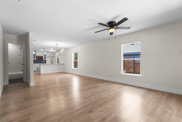 2117 Andrew Ave, Fort Worth, TX 76105 - unfurnished living room with a chandelier, ceiling fan, and light wood-style flooring