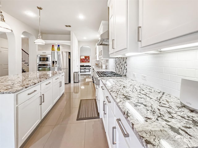 1500 Whistle Brook Dr, Allen, TX 75013 - kitchen with appliances with stainless steel finishes, arched walkways, white cabinetry, tasteful backsplash, and recessed lighting