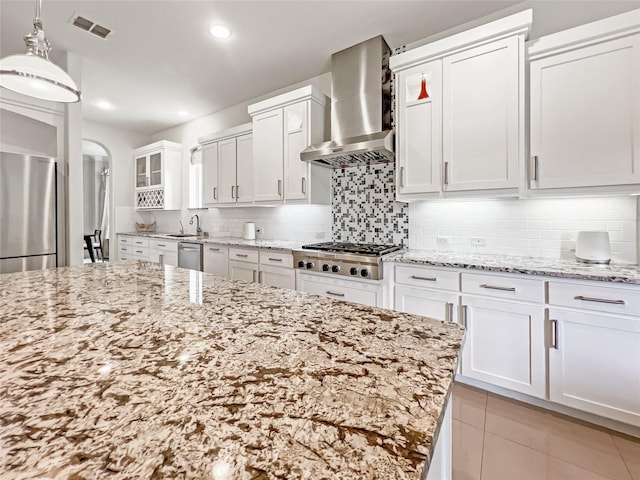 1500 Whistle Brook Dr, Allen, TX 75013 - kitchen featuring wall chimney exhaust hood, stainless steel appliances, white cabinets, tasteful backsplash, and light stone counters