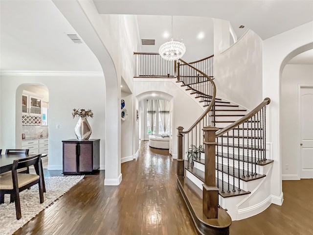 1500 Whistle Brook Dr, Allen, TX 75013 - entryway with arched walkways, wood finished floors, stairway, a chandelier, and crown molding