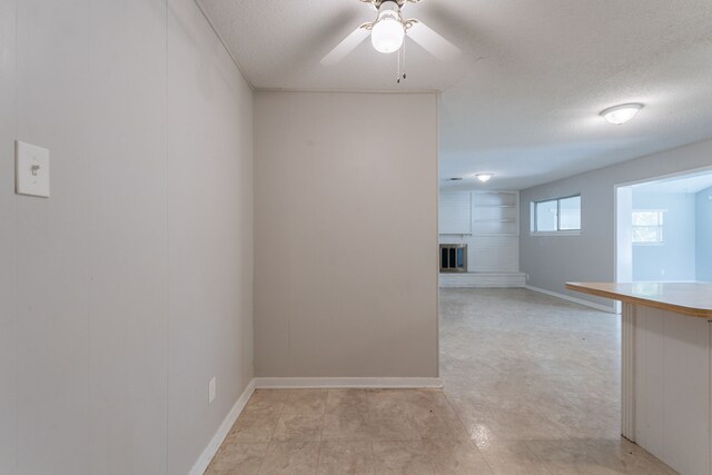 5905 Wheaton Dr, Fort Worth, TX 76133 - spare room with a fireplace, ceiling fan, and a textured ceiling
