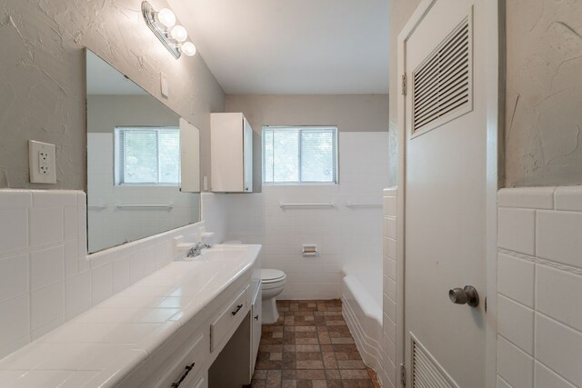 5905 Wheaton Dr, Fort Worth, TX 76133 - bathroom featuring healthy amount of natural light, vanity, a tub to relax in, and tile walls