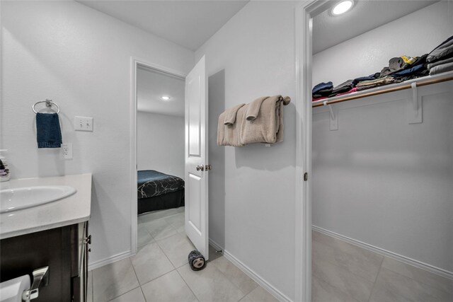 3165 Crestone Dr, Crandall, TX 75114 - ensuite bathroom featuring vanity, a walk in closet, tile patterned flooring, and recessed lighting