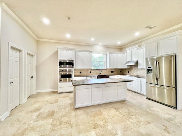 1016 Santiago Trl, Wylie, TX 75098 - kitchen with stainless steel appliances, under cabinet range hood, crown molding, white cabinetry, and backsplash