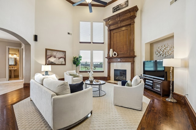 211 Tanner Creek Cir, Sunnyvale, TX 75182 - living area with a high ceiling, ceiling fan, ornamental molding, a glass covered fireplace, and arched walkways