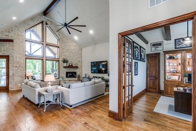 217 The Falls Dr, Sunnyvale, TX 75182 - living area with beamed ceiling, a stone fireplace, high vaulted ceiling, light wood-style flooring, and ceiling fan