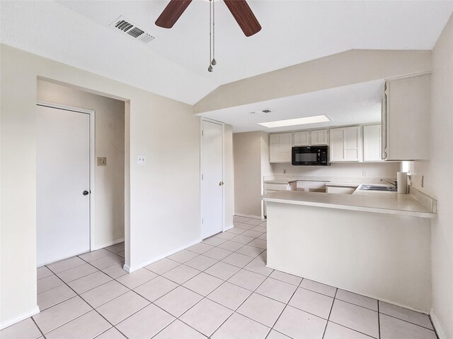 631 Sharp St, Mansfield, TX 76063 - kitchen featuring black microwave, light countertops, a ceiling fan, and light tile patterned flooring