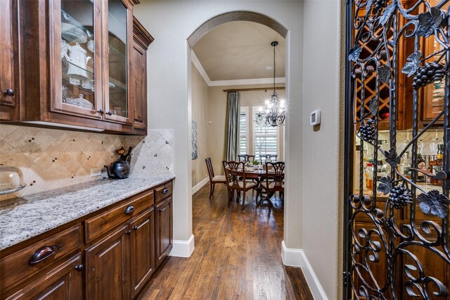 917 Stone Cottage Ln, Mckinney, TX 75069 - wine cellar with arched walkways, dark wood-style floors, a chandelier, and ornamental molding