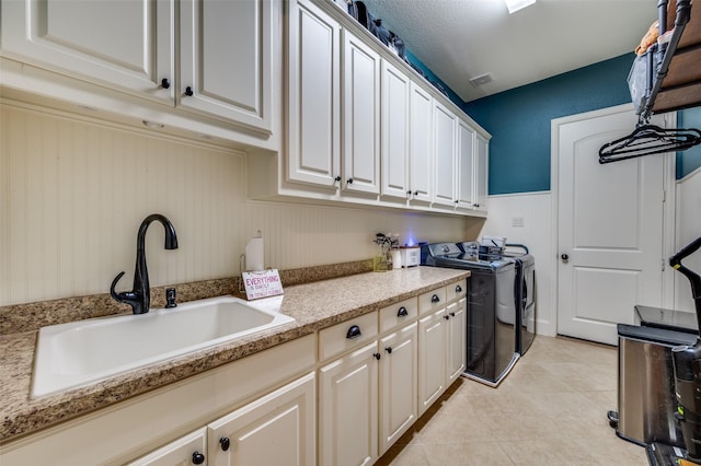 917 Stone Cottage Ln, Mckinney, TX 75069 - laundry room with cabinet space, washer and clothes dryer, a wainscoted wall, and light tile patterned floors