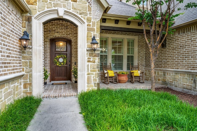 917 Stone Cottage Ln, Mckinney, TX 75069 - property entrance featuring brick siding, stone siding, covered porch, and a shingled roof