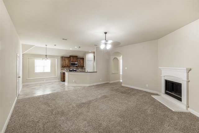1701 Fair Oaks Ln, Royse City, TX 75189 - unfurnished living room with light carpet, arched walkways, a ceiling fan, and a fireplace