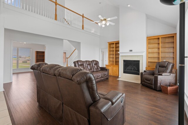 2008 Natchez Ct, Cleburne, TX 76033 - living room featuring high vaulted ceiling, dark wood finished floors, ceiling fan, stairs, and a tile fireplace