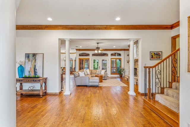 10133 Leaping Buck Pt, Fort Worth, TX 76126 - living area featuring decorative columns, ceiling fan, crown molding, light wood-style floors, and stairs