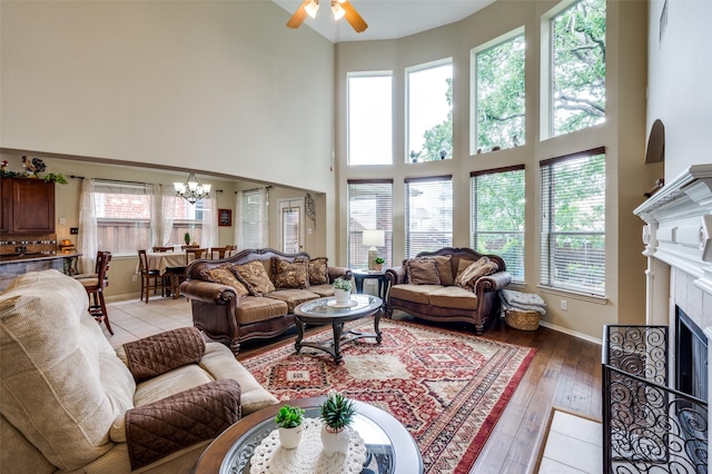 216 Barkley Dr, Hickory Creek, TX 75065 - living room with a high ceiling, a chandelier, a ceiling fan, a fireplace with flush hearth, and light wood finished floors
