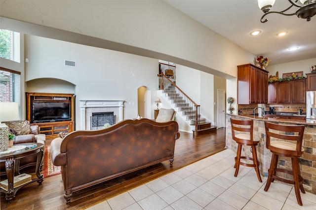 216 Barkley Dr, Hickory Creek, TX 75065 - kitchen featuring stainless steel fridge with ice dispenser, open floor plan, light tile patterned flooring, a fireplace, and a kitchen bar